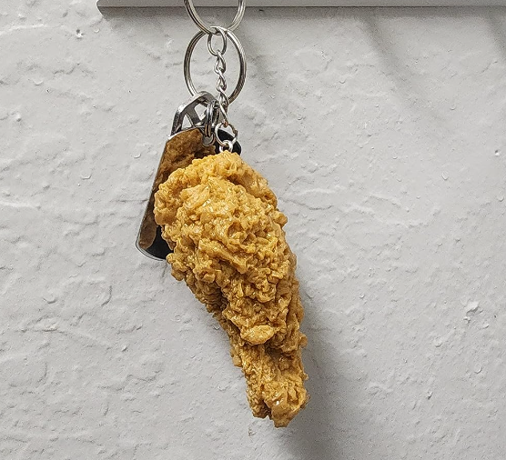 A reviewer's chicken wing keychain hanging from a key hook
