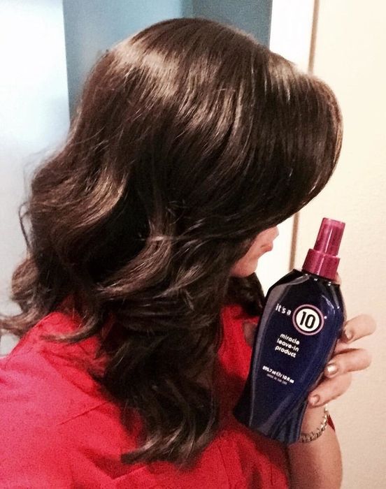 Reviewer holding a product while showcasing their hair