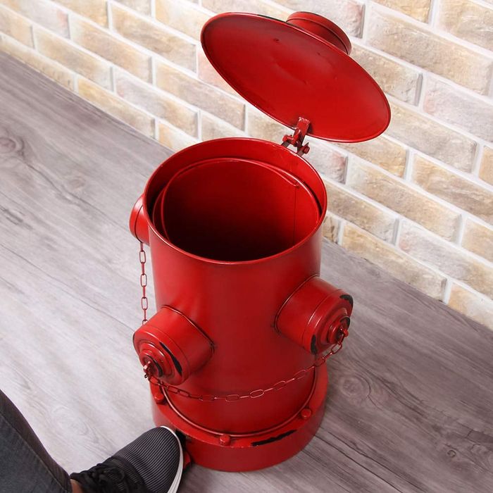 Step to open an iron garbage can shaped like a fire hydrant