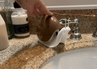A gif of a person’s hand dispensing soap from the snail-shaped soap dispenser