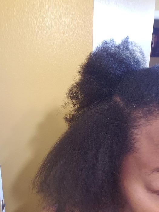 Person with 4c hair having a section of it blown out