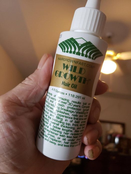 A reviewer holds the product in their hand, showcasing its packaging.