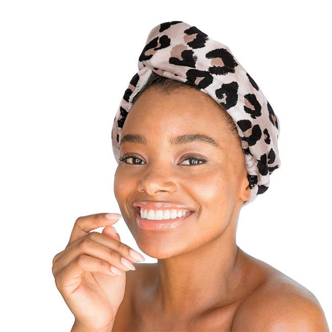 A Black model wearing a leopard print towel turban wrapped around their head.