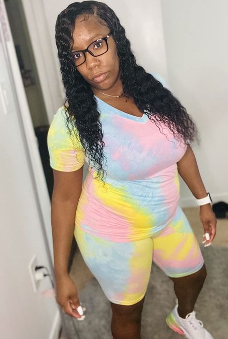 A reviewer flaunts a blue, pink, and yellow tie-dye workout set, exuding energy and style.