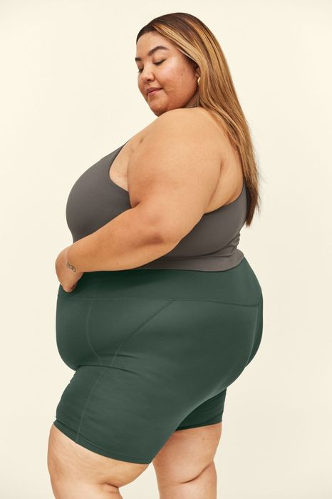 side view of a model wearing the green bike shorts