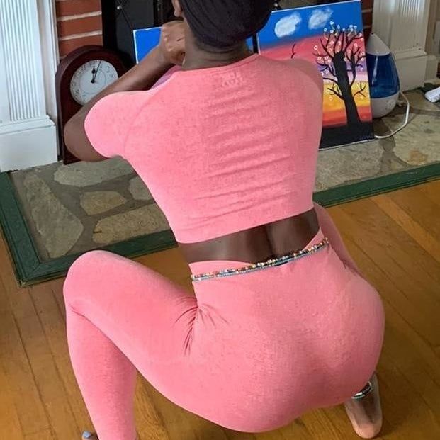 back view of reviewer wearing the pink set while performing a squat