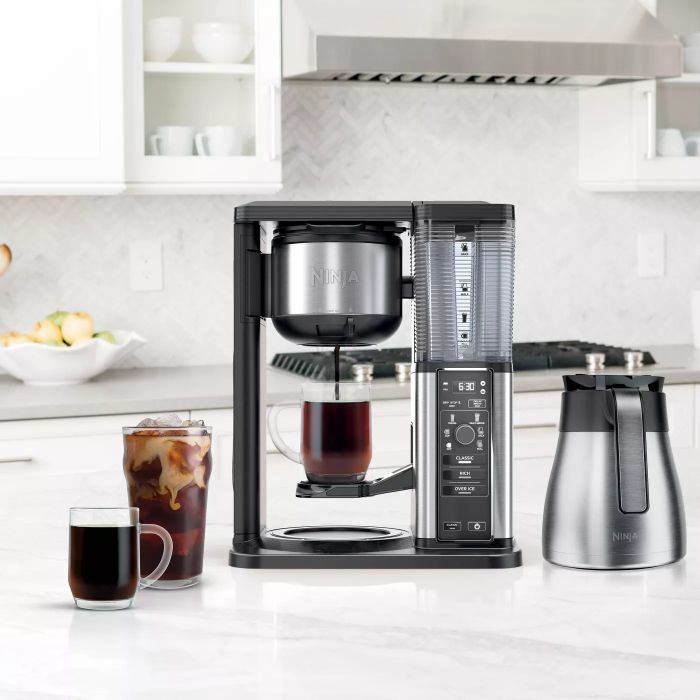 The coffee maker sitting on a countertop, brewing a fresh cup of coffee.