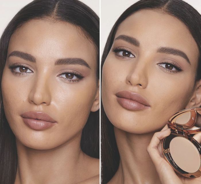 A person displaying their makeup while holding a compact powder