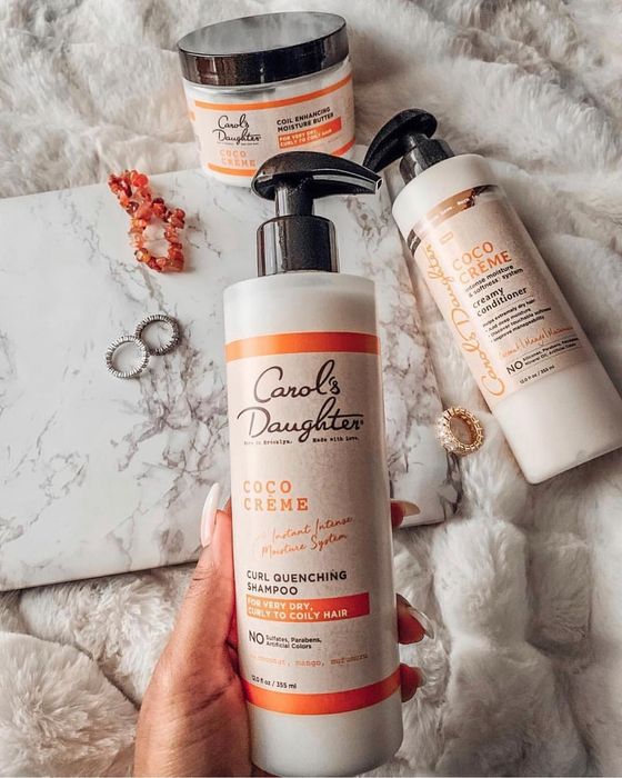 A hand gripping the shampoo bottle