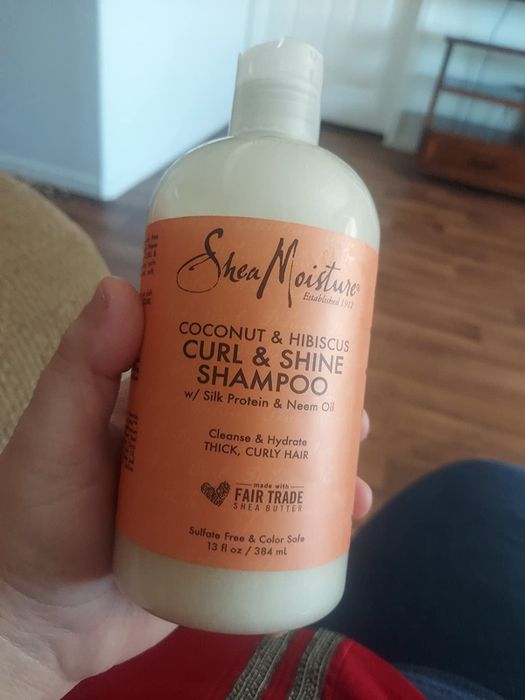 A reviewer holding the shampoo bottle