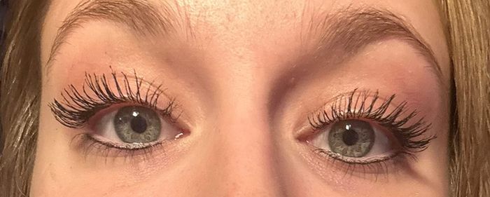 A reviewer's lashes after applying the mascara, looking dramatically long as if they were falsies