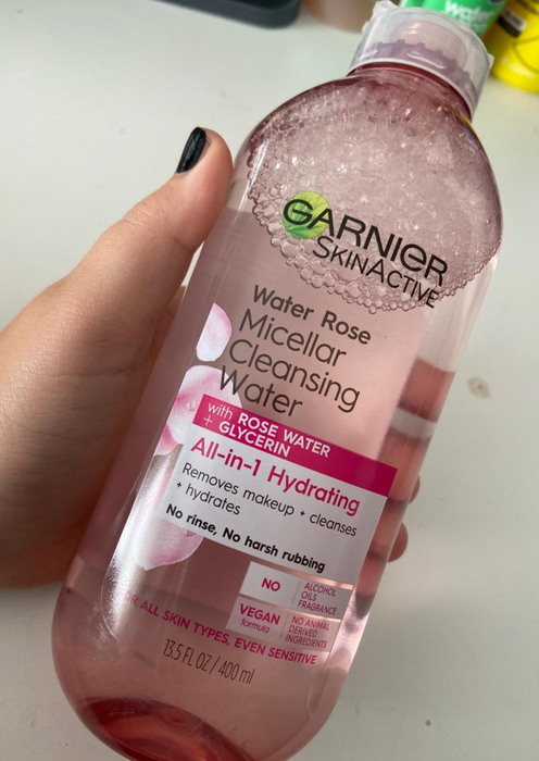A reviewer showing off a bottle of Garnier Micellar Water