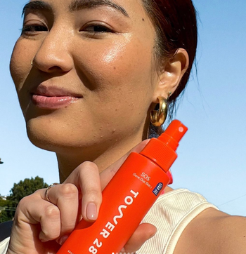 A model happily holding the Tower 28 SOS spray