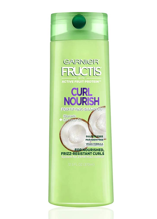 A bottle of Curl Nourish shampoo, designed to enhance and maintain curly hair.