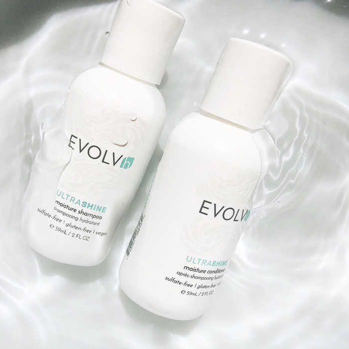 Shampoo and conditioner bottles submerged in water.