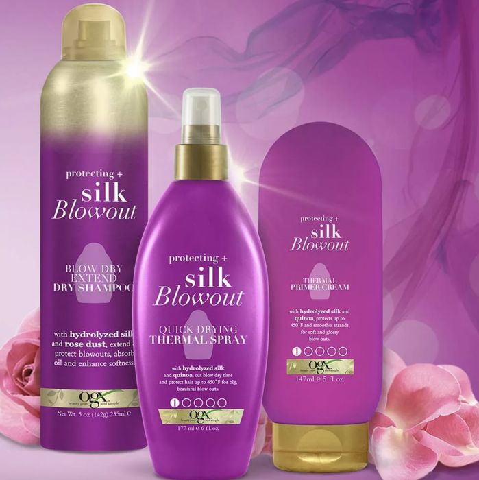 A bottle of thermal spray, primer cream, and dry shampoo