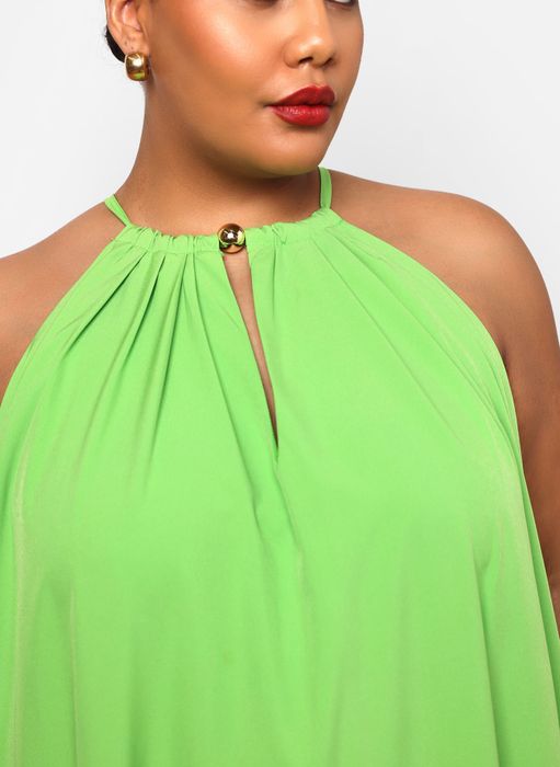 A stylish woman in a halter-neck top featuring gold accents, perfect for shopping inspiration.