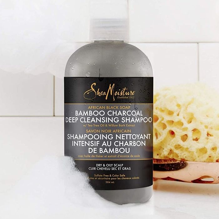 The shampoo placed beside a sponge in a bathroom setting