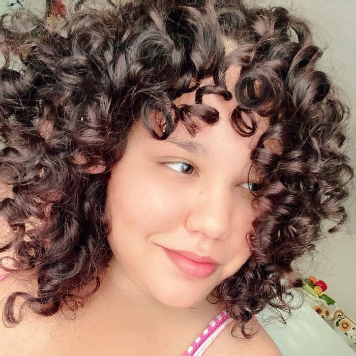 An individual with curly brown hair experienced remarkable results after incorporating Garnier shampoo and conditioner into their hair care routine.