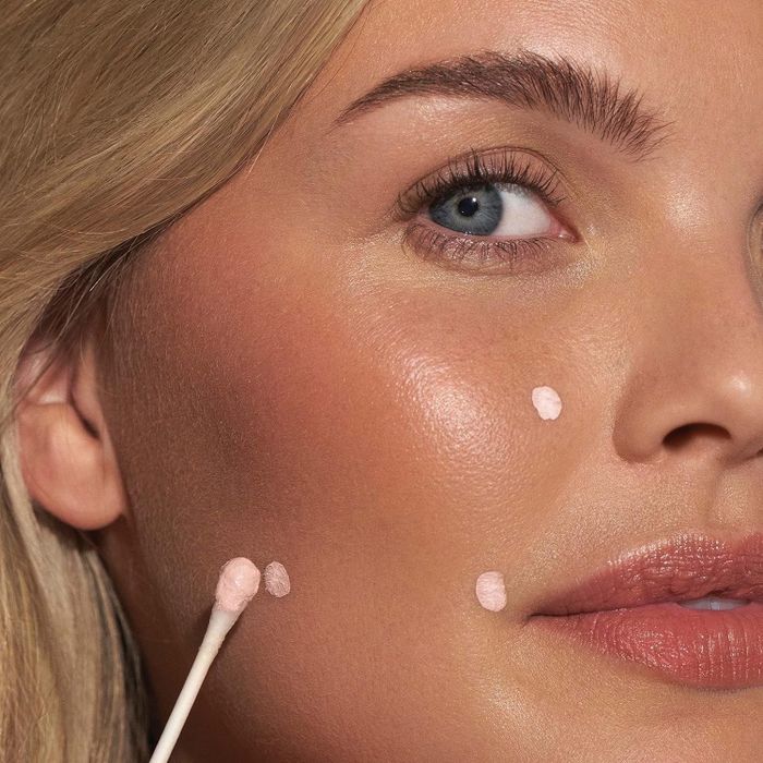a person applying the drying cream on their face