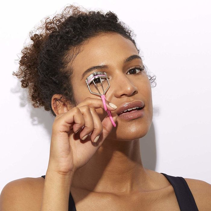 a model demonstrating the use of an eyelash curler