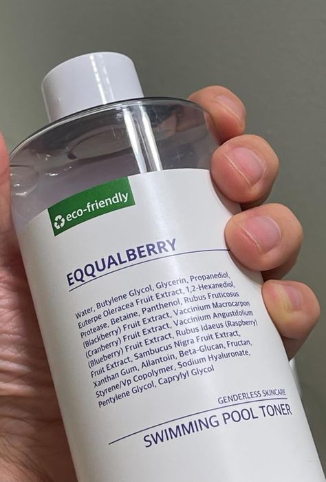 A hand holding a bottle of