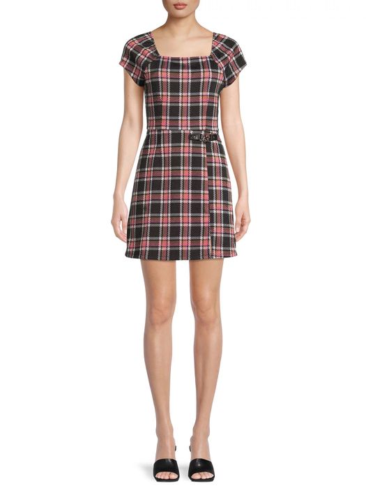 The model is featured in the plaid dress, highlighting its charming and versatile design.