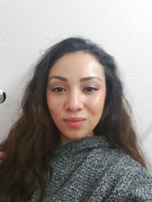 a reviewer showcasing radiant, dewy skin after using the product