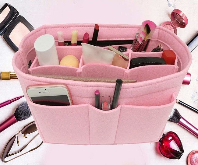 The organizer packed with various items, such as makeup brushes, a phone, beauty products, and more