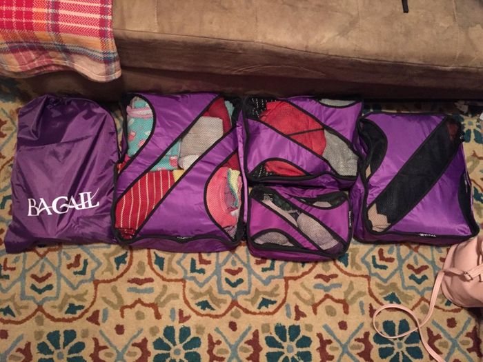 The same reviewer demonstrating how everything fits neatly into the packing cubes