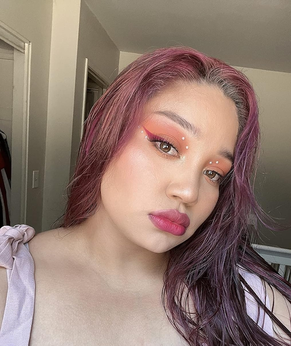 The reviewer wearing a full face of makeup