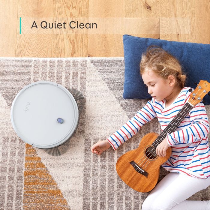 The robotic vacuum positioned beside a peacefully sleeping child