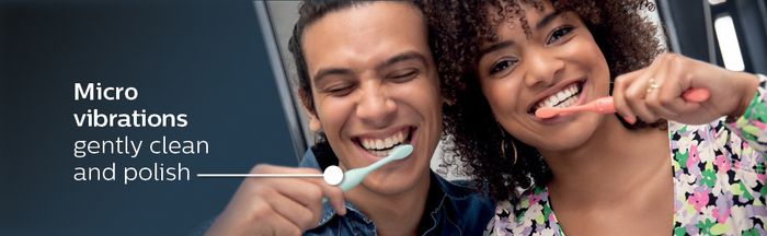 Models demonstrating the use of blue and pink toothbrushes