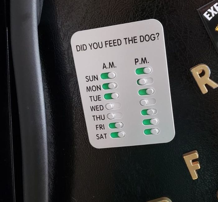 The dog feeding tracker is attached to a refrigerator.