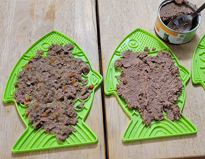 two green fish-shaped lick mats topped with wet food