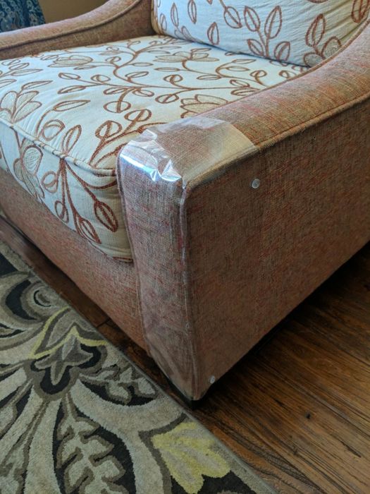 A reviewer's photo showing the transparent protector applied to the leg of a recliner.
