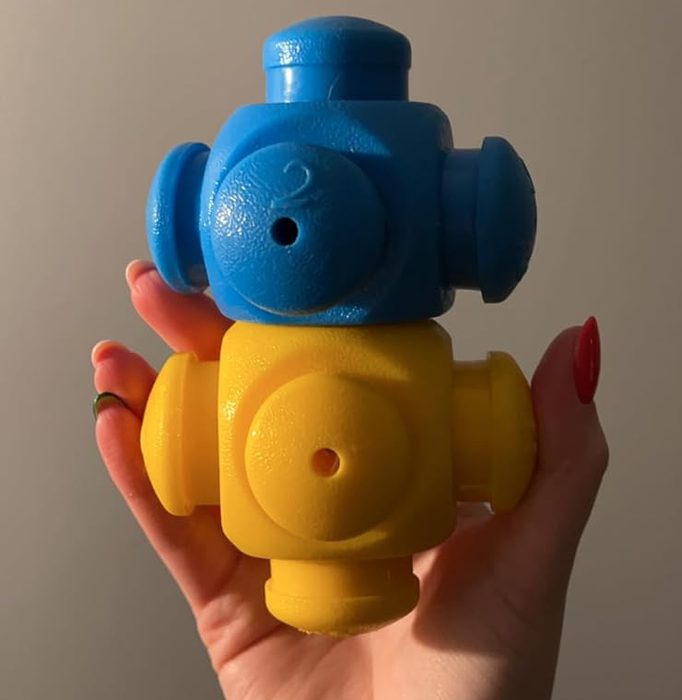 A reviewer holding a blue and yellow piece stacked together