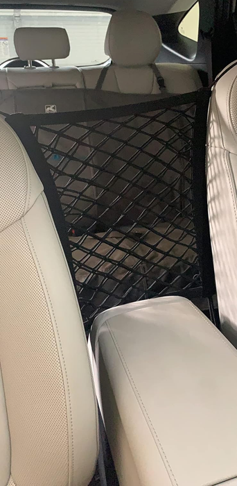 a net barrier installed in a car, separating the front and back seats