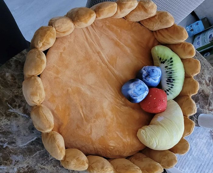 The whimsical cat bed complete with fruit-shaped toys.