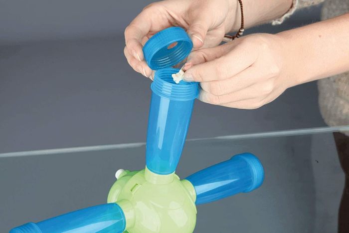 A person placing treats into the beakers on the windmill