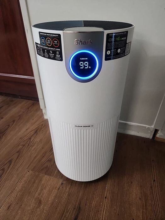 A reviewer's photo of the large white tower Shark air purifier.