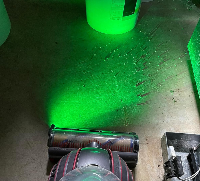 A reviewer's photo of the same corner illuminated by the light, revealing a surprising amount of crumbs and debris that need vacuuming