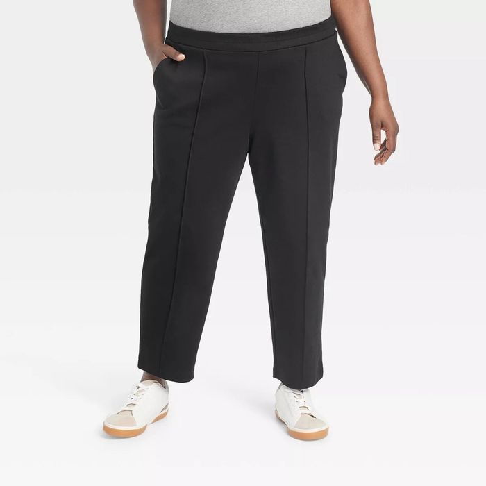 A person is sporting a relaxed look with black pants and white sneakers