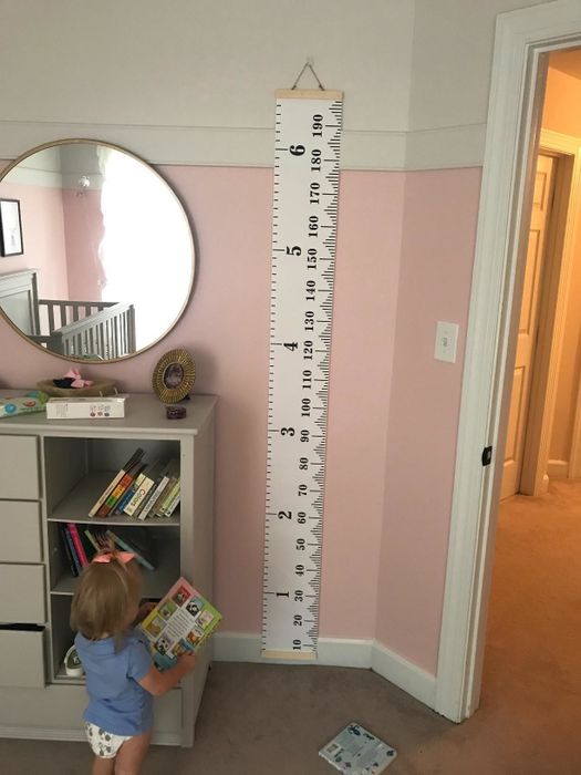 Reviewer's photo displaying the canvas growth chart in their child's play area