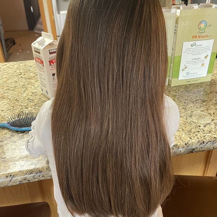 An after photo from a reviewer displaying smooth, tangle-free hair after using the brush