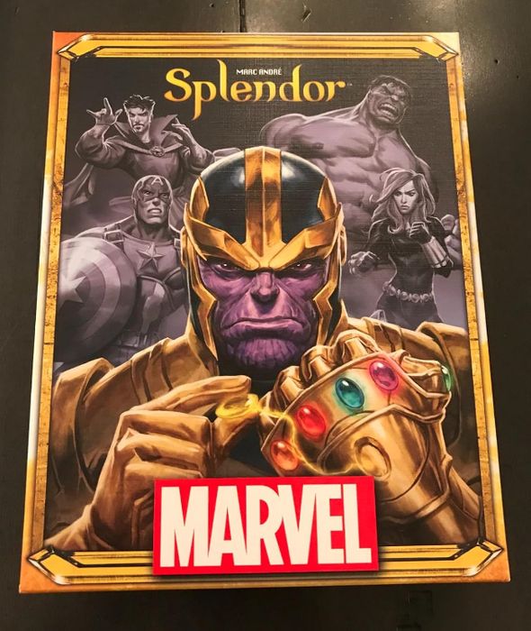 reviewer's Marvel Splendor board game showcasing Thanos with the Infinity Gauntlet, alongside characters like Captain America and Hulk