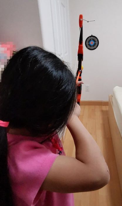 a reviewer's child aiming a bow and arrow