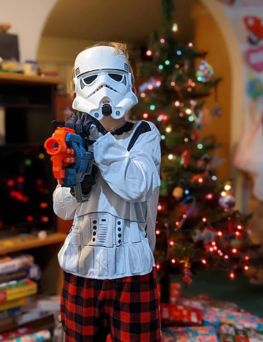 a reviewer's child wearing a Stormtrooper helmet and posing with a blaster