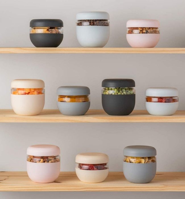glass containers with colorful silicone sleeves in various sizes displayed on a shelf