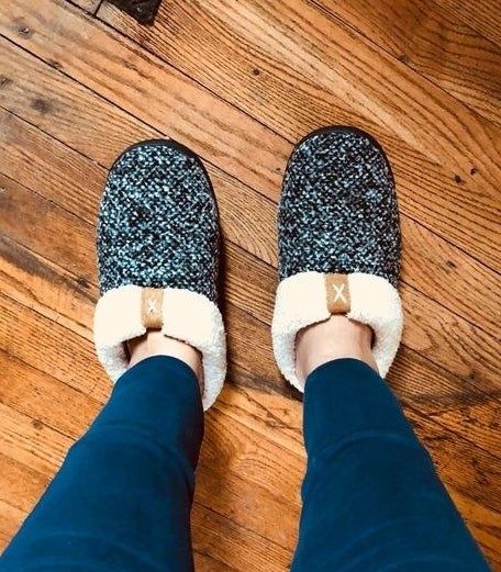 reviewer's feet wearing tweed and shearling slippers with open backs